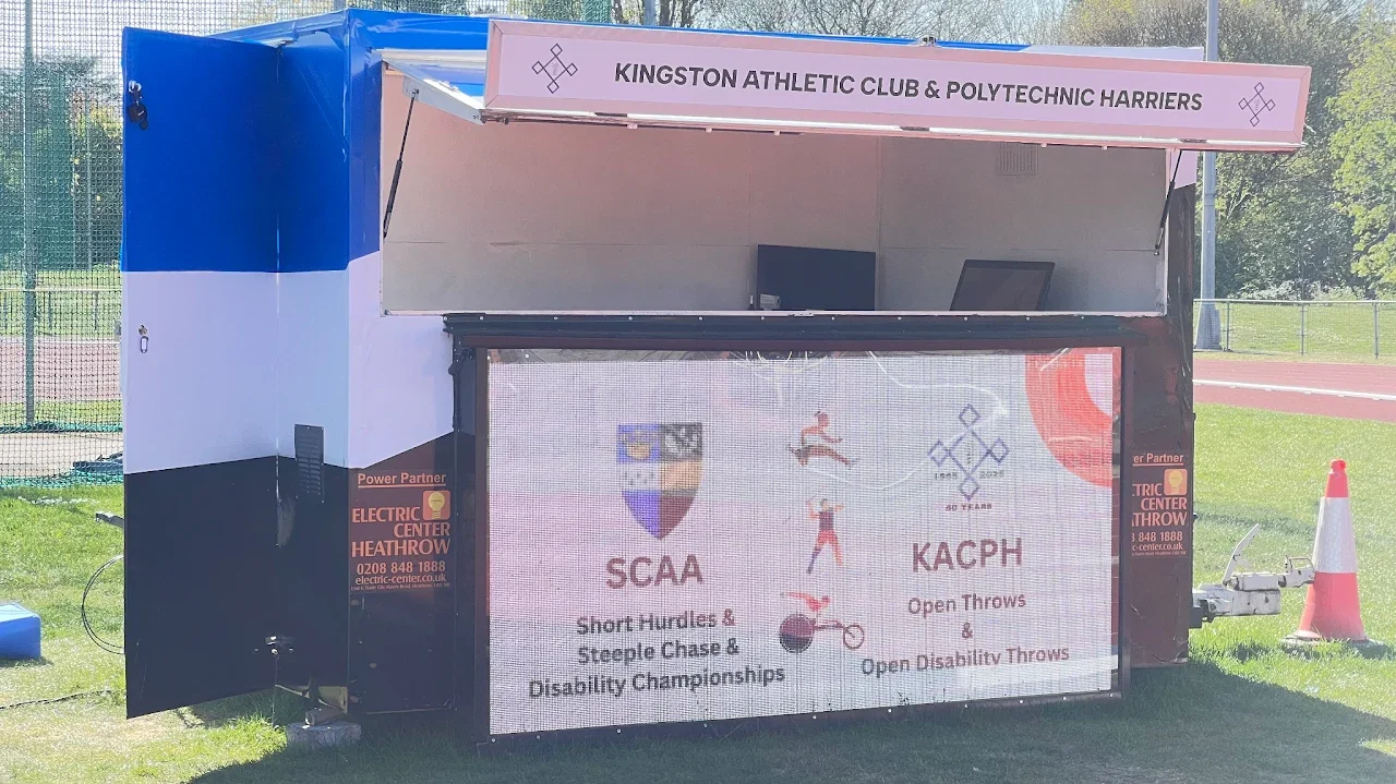 The Kingston AC & Polytechnic Harriers gazebo at a track meeting, with the PolyField display screen
